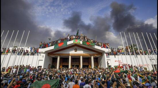 People gather around the residence of Bangladeshi prime minister in Dhaka, Bangladesh, Monday. (PTI)