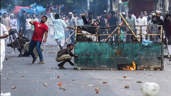 Protesters in Dhaka pelt stones as they clash with police during the ongoing anti-quota agitation (AFP Photo)