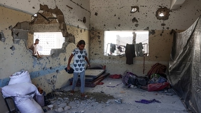 A young Palestinian woman checks the damage inside a classroom at the al-Zahra school used as a refuge by displaced Palestinians. (AFP) A young Palestinian woman checks the damage inside a classroom at the al-Zahra school used as a refuge by displaced Palestinians. (AFP)
