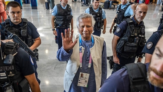 Bangladesh's finance pioneer Muhammad Yunus (C) is escorted by French police personnel as he arrives at Roissy-Charles de Gaulle Airport, north of Paris enroute to Bangladesh.