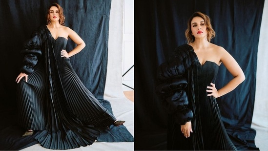 Huma Qureshi's latest look is the epitome of sartorial elegance as she stuns in an off-shoulder black flared gown, paired with a puffed jacket casually draped over one shoulder. With bold lips and curled tresses, she exudes undeniable glamour.(Instagram)