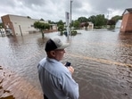Randy Sikes speaks to his relatives on a mobile phone as he stands in residual rain water flooding the downtown area caused by Tropical Storm Debby, Thursday, Aug. 8, 2024, in Bladenboro, NC. (AP Photo/John Minchillo)(AP) Randy Sikes speaks to his relatives on a mobile phone as he stands in residual rain water flooding the downtown area caused by Tropical Storm Debby, Thursday, Aug. 8, 2024, in Bladenboro, NC. (AP Photo/John Minchillo)(AP)