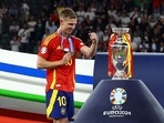 Spain's Dani Olmo celebrates near the trophy after winning the Euro 2024 
