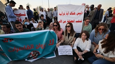 Iraqi men join women in a demonstration against underage marriage in Tahrir Square in central Baghdad on August 8, 2024, amid parliamentary discussions over a proposed amendment to the Iraqi Personal Status Law. (AFP)