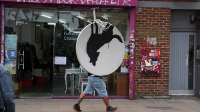 Man making off with the stolen Banksy piece Man making off with the stolen Banksy piece
