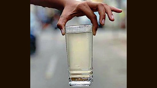 One of the residents Jeevan Nagar showing the glass of contaminated water running from the tap in Ludhiana on Friday. (HT Photo)