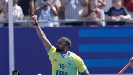 India's captain Harmanpreet Singh carries India's goalkeeper Parattu Reveendran Sreejesh on his shoulders as India's players take a victory lap (AP)