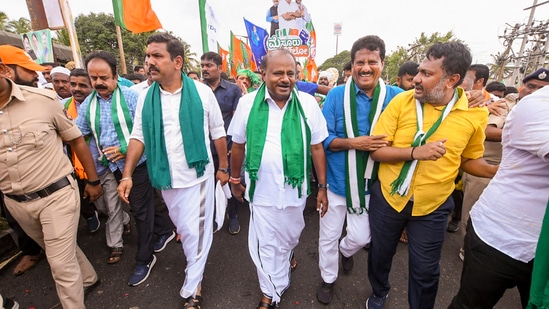 H.D. Kumaraswamy and Karnataka BJP President B.Y. Vijayendra with BJP and JD(S) workers during a week-long 'padyatra' from Bengaluru to Mysuru.(PTI)