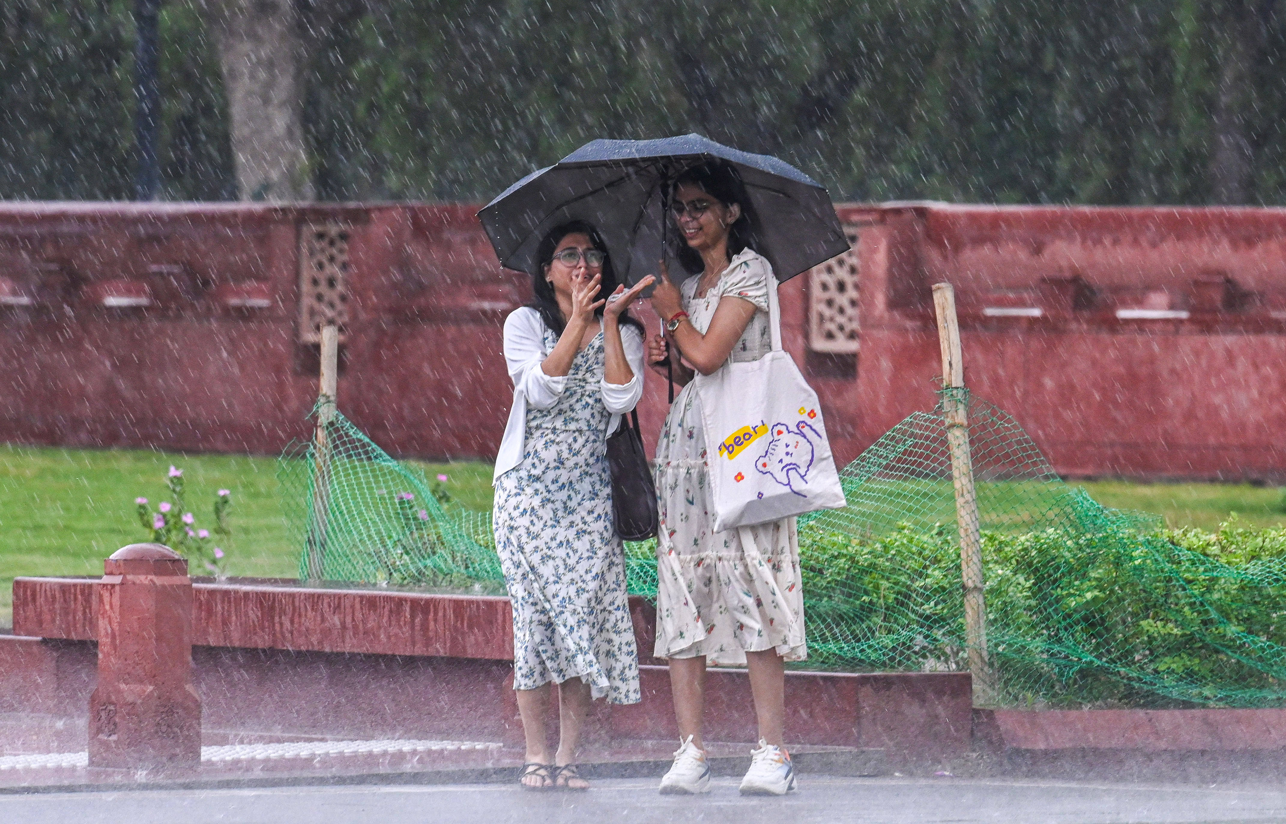 These youngsters had a blast enjoying the downpour under the shade of their umbrella.(Photo: Raj K Raj/HT)