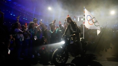 Tom Cruise rides a motorbike with the Olympic flag attached during the 2024 Summer Olympics closing ceremony at the Stade de France (AP) Tom Cruise rides a motorbike with the Olympic flag attached during the 2024 Summer Olympics closing ceremony at the Stade de France (AP)
