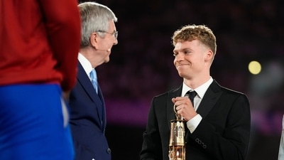 French swimmer Leon Marchand carries a lantern containing the Olympic flame with IOC President Thomas Bach, left, during the 2024 Summer Olympics closing ceremony at the Stade de France (AP) French swimmer Leon Marchand carries a lantern containing the Olympic flame with IOC President Thomas Bach, left, during the 2024 Summer Olympics closing ceremony at the Stade de France (AP)