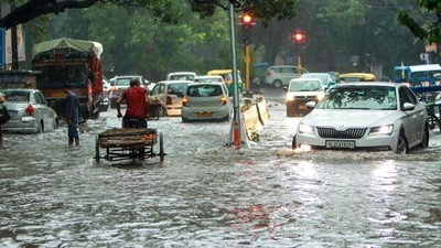 Vehicles pass through a waterlogged road in Jangpura in Delhi on Sunday. (HT Photo) Vehicles pass through a waterlogged road in Jangpura in Delhi on Sunday. (HT Photo)