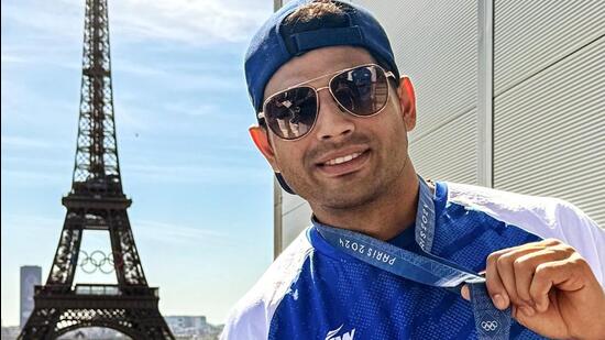 India's javelin thrower Neeraj Chopra poses for a picture with his silver medal against the iconic backdrop of the Eiffel Tower. (Doordarshan Sports- X)