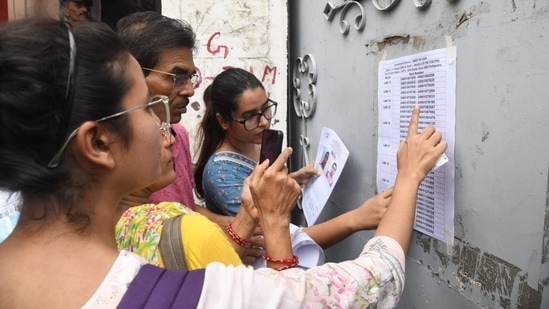 Candidates check their hall ticket numbers to appear for NEET PG 2024 exam in Patna.(Santosh Kumar)