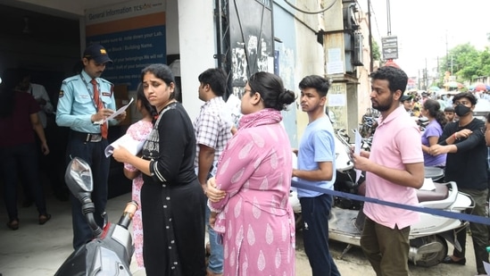 Security officials check admit cards of candidates who wait to enter the exam hall to appear for NEET PG 2024 exam in Patna(Santosh Kumar)