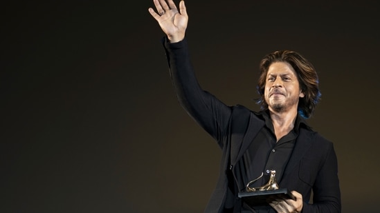 Shah Rukh Khan with his award on the Piazza Grande area during the 77th Locarno International Film Festival, in Locarno, Switzerland.(AP)