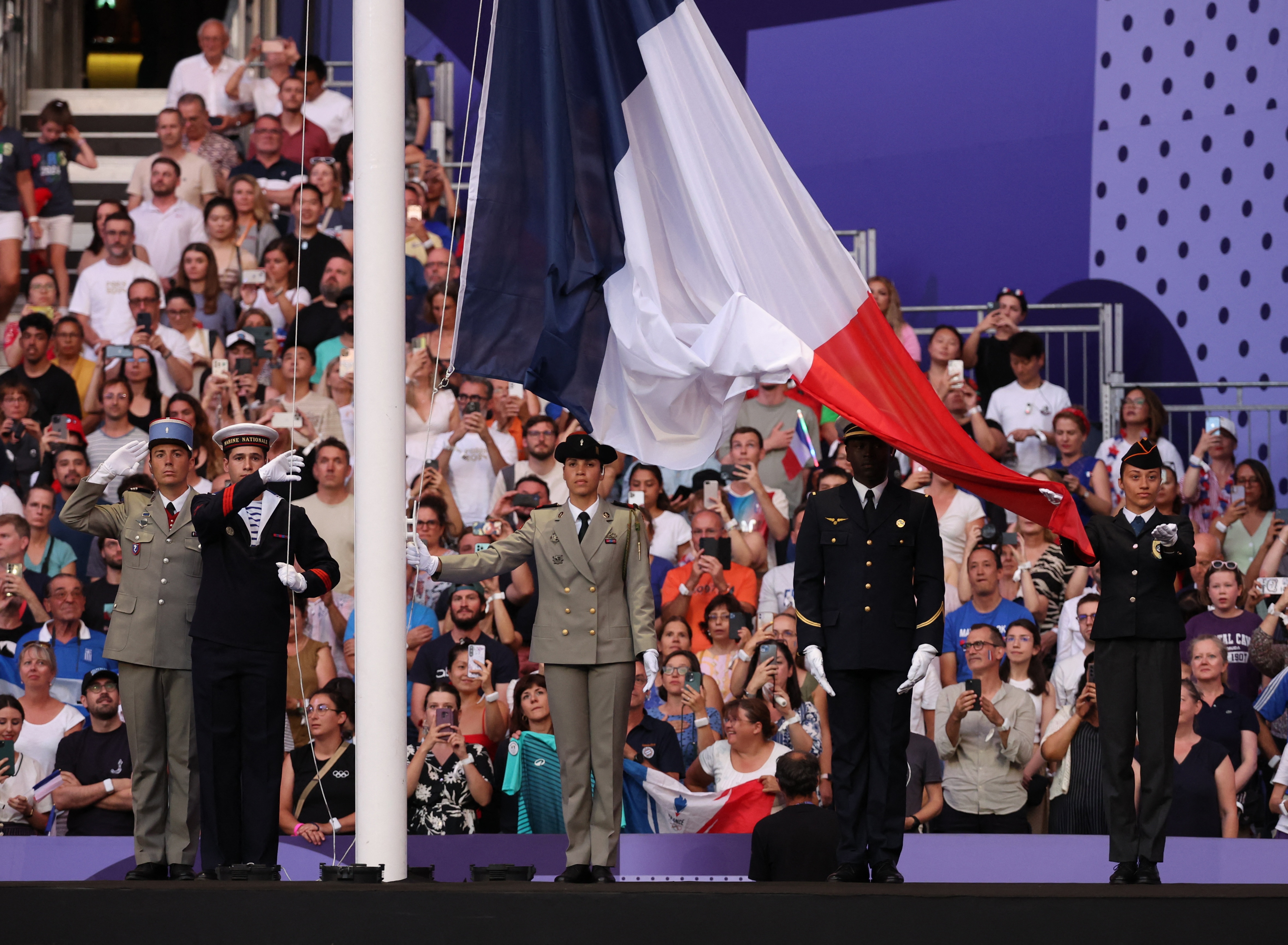 Members of the military raise the flag of France during the closing ceremony (REUTERS)