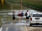 Eric Combs, Maverick Knight and Michelle Knight paddle away as they traverse high water along Canisteo River Road in Canisteo, N.Y., Friday, Aug. 9, 2024, after remnants of Tropical Storm Debby swept through the area. (AP Photo/Craig Ruttle)(AP08_10_2024_000058B)(AP) Eric Combs, Maverick Knight and Michelle Knight paddle away as they traverse high water along Canisteo River Road in Canisteo, N.Y., Friday, Aug. 9, 2024, after remnants of Tropical Storm Debby swept through the area. (AP Photo/Craig Ruttle)(AP08_10_2024_000058B)(AP)