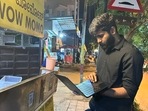 Only in Bengaluru: A man works on his laptop while waiting for food.