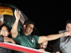 Arshad Nadeem, Pakistan's first Olympic gold medalist athlete in the men's javelin, waves from the roof of a vehicle to fans who gathered to welcome him on his arrival, outside the Allama Iqbal International Airport, in Lahore