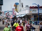 Visitors stroll past arcades on the boardwalk in Wildwood, N.J. US Myrtle Beach to Wildwood: Waterfront shops see surge in summer tourist traffic and sales (AP Photo/Matt Rourke)