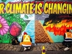 Street artists paint a mural on climate change. (AFP File Photo)