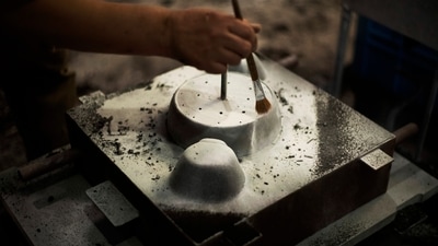 Craftsman Katsunori Suzuki uses a brush to bring up a contour of a cooking pot to make detailed designs as he makes a cast iron pot by hand at the Oigen foundry in Oshu, northeastern Japan. (AP Photo/Hiro Komae) Craftsman Katsunori Suzuki uses a brush to bring up a contour of a cooking pot to make detailed designs as he makes a cast iron pot by hand at the Oigen foundry in Oshu, northeastern Japan. (AP Photo/Hiro Komae)