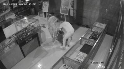 There were about 10-12 members in the gang who stood outside the showroom and two of them open the main shutter with the help of some equipment to enter the showroom. (HT Photo (Video grabs)) There were about 10-12 members in the gang who stood outside the showroom and two of them open the main shutter with the help of some equipment to enter the showroom. (HT Photo (Video grabs))