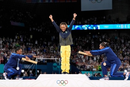 Silver medalist Simone Biles, of the United States, left, and bronze medalist Jordan Chiles, of the United States, right, bow to gold medalist Rebeca Andrade, of Brazil, during the medal ceremony for the women's artistic gymnastics. (AP) Silver medalist Simone Biles, of the United States, left, and bronze medalist Jordan Chiles, of the United States, right, bow to gold medalist Rebeca Andrade, of Brazil, during the medal ceremony for the women's artistic gymnastics. (AP)
