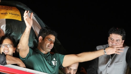 Arshad Nadeem, Pakistan's first Olympic gold medalist athlete in the men's javelin, waves from the roof of a vehicle to fans who gathered to welcome him on his arrival, outside the Allama Iqbal International Airport, in Lahore(REUTERS)