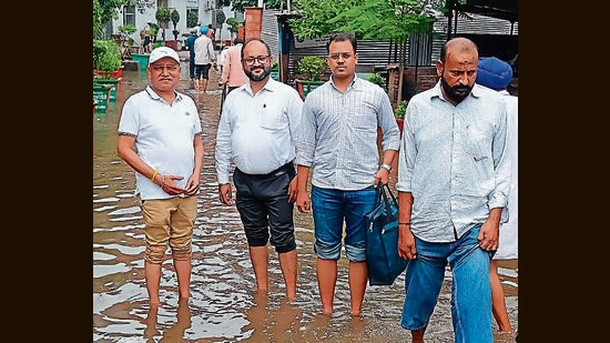 Residents on a waterlogged lane outside Ambala district courts on Monday. (HT Photo)