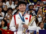 China's silver medallist He Bing Jiao celebrates with her medal on the podium at the women's singles badminton medal ceremony during the Paris 2024 Olympic Games.(AFP) China's silver medallist He Bing Jiao celebrates with her medal on the podium at the women's singles badminton medal ceremony during the Paris 2024 Olympic Games.(AFP)