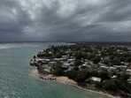 A drone view shows storm clouds over a coastal community as Tropical Storm Ernesto approaches Loiza, Puerto Rico, August 13, 2024.  REUTERS/Ricardo Arduengo