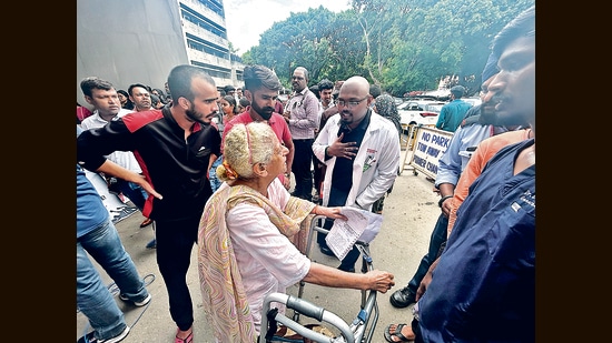 76-year-old cancer patient Lajwanti Vasudeva, who arrived at PGIMER from Panchkula with her daughter for a scheduled knee surgery, seeking clarity from a protesting doctor. (HT Photo)