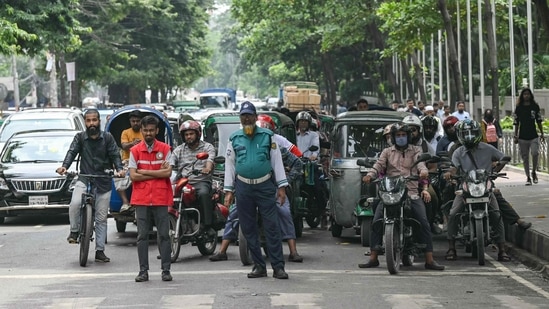 A student volunteer (L) and police personnel controls traffic after the Bangladeshi police force resumed duty, in Dhaka. (AFP)