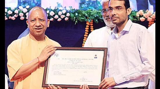 Chief minister Yogi Adityanath gives appointment letter to a candidate selected through a recruitment process by Uttar Pradesh Subordinate Services Selection Commission (UPSSSC), in Lucknow on Tuesday. (ANI Photo)