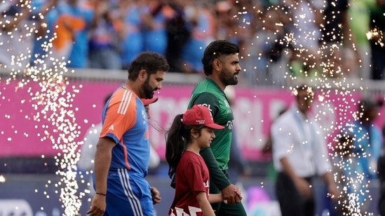 Pakistan's captain Babar Azam, right, and India's captain Rohit Sharma walk into the field before the start of the ICC Men's T20 World Cup cricket match (PTI)