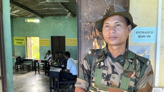 A security personnel stands guard outside a polling booth for three-tier Panchayat elections at Ballabpur under Suryamaninagar, in West Tripura district. (PTI)