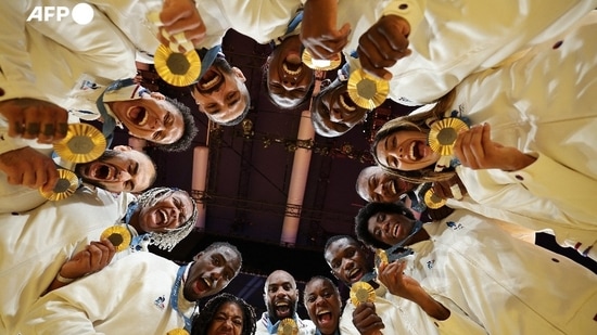 The French judokas were celebrating on August 3 after winning their second Olympic mixed team title against Japan, thanks especially to two victories by superstar Teddy Riner. The moment was captured by Jack Guez, who slid underneath the group. He had hoped to do the same at the Tokyo Games in 2021, where France also bested Japan, but the International Judo Federation did not allow access to the mat. 