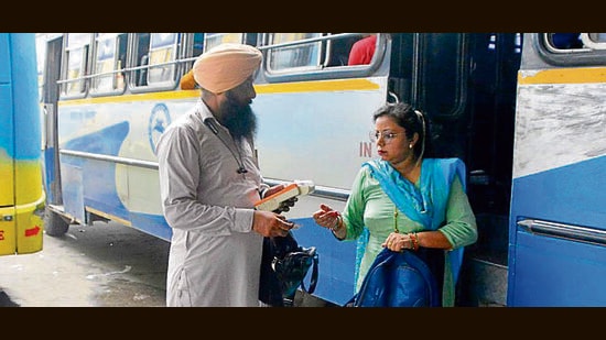 A conductor issuing a ticket using electronic ticket machine at Bus Stand in Ludhiana. (Manish/HT)