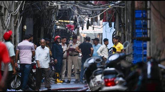 Firefighters in the congested lane where the fire broke out. (RAJ K RAJ /HT PHOTO)