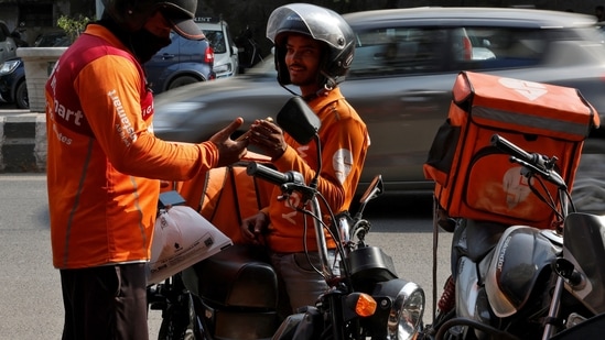 Gig workers prepare to deliver orders outside Swiggy's grocery warehouse at a market area in New Delhi, India, May 6, 2024. (Priyanshu Singh/Reuters)