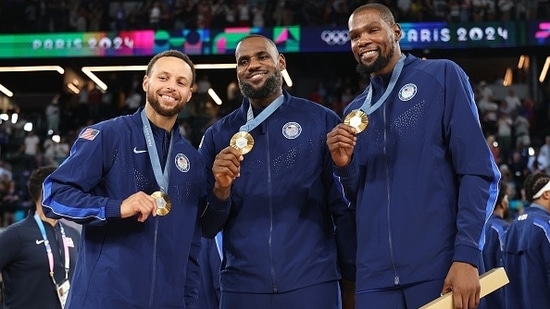 Stephen Curry, LeBron James and Kevin Durant of Team United States pose with the Olympic gold medal.(Getty)