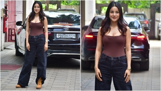 Today, Shehnaaz Gill stepped out in Mumbai dressed in a stylish brown bodysuit and dark blue denim jeans. She styled the ensemble with loose centre-parted hair, heeled tan suede boots, pink lips, and minimal dewy makeup. (HT Photo/Varinder Chawla)