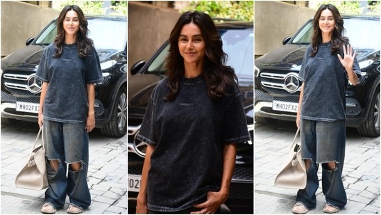 Shibani Dandekar was the picture of casual elegance as the paparazzi snapped her in a grey printed oversized tee and baggy denim jeans featuring distressed knee detail. She wore the ensemble with sneakers, a tote bag, and a no-makeup look. (HT Photo/Varinder Chawla)