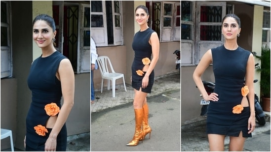 Vani Kapoor promoted her upcoming movie Khel Khel Mein in a David Koma black mini dress and boots from his Spring 2024 collection. The sleeveless ensemble features a tiny slit, a cut-out on the waist, and orange floral adornments on the front. (HT Photo/Varinder Chawla)