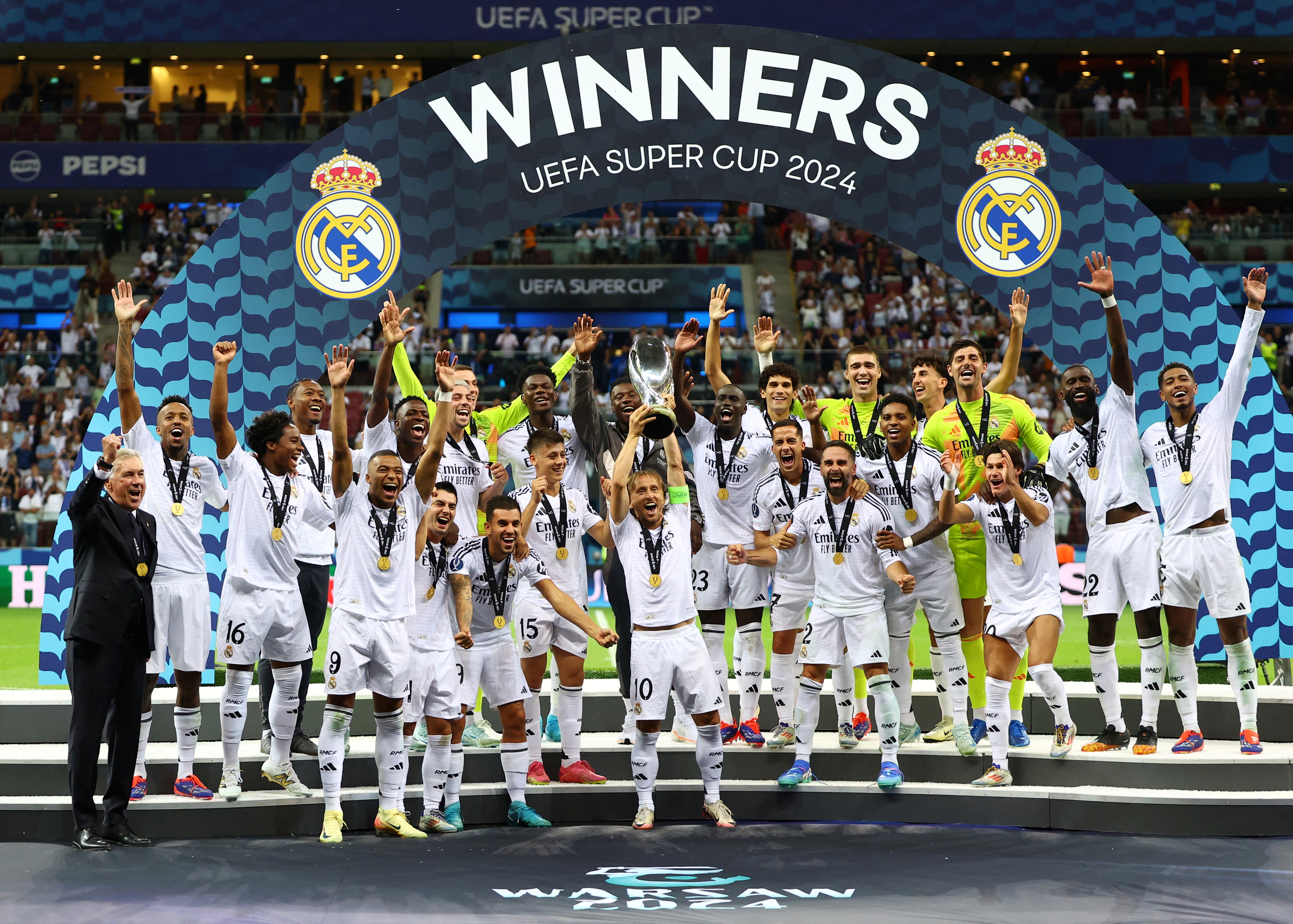 Real Madrid legend Luka Modric lifts the trophy as he celebrates with teammates after winning the Super Cup (REUTERS)