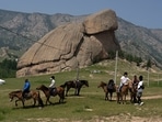 Tourists enjoy horseback riding near the iconic Turtle Rock outcrop at the Terejl National Park outside Ulaanbaatar, Mongolia. (AP)