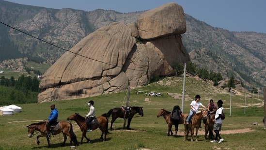 Tourists enjoy horseback riding near the iconic Turtle Rock outcrop at the Terejl National Park outside Ulaanbaatar, Mongolia. (AP)