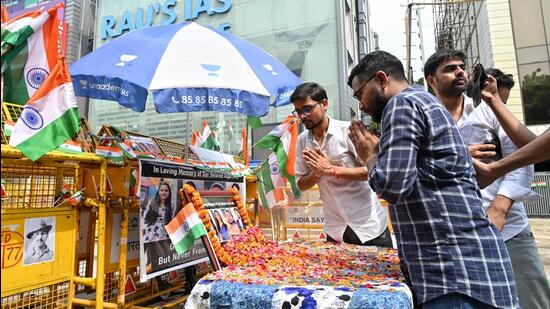 Students fold their hands in respect of the three who died of waterlogging. (Sanchit Khanna/HT Photo)